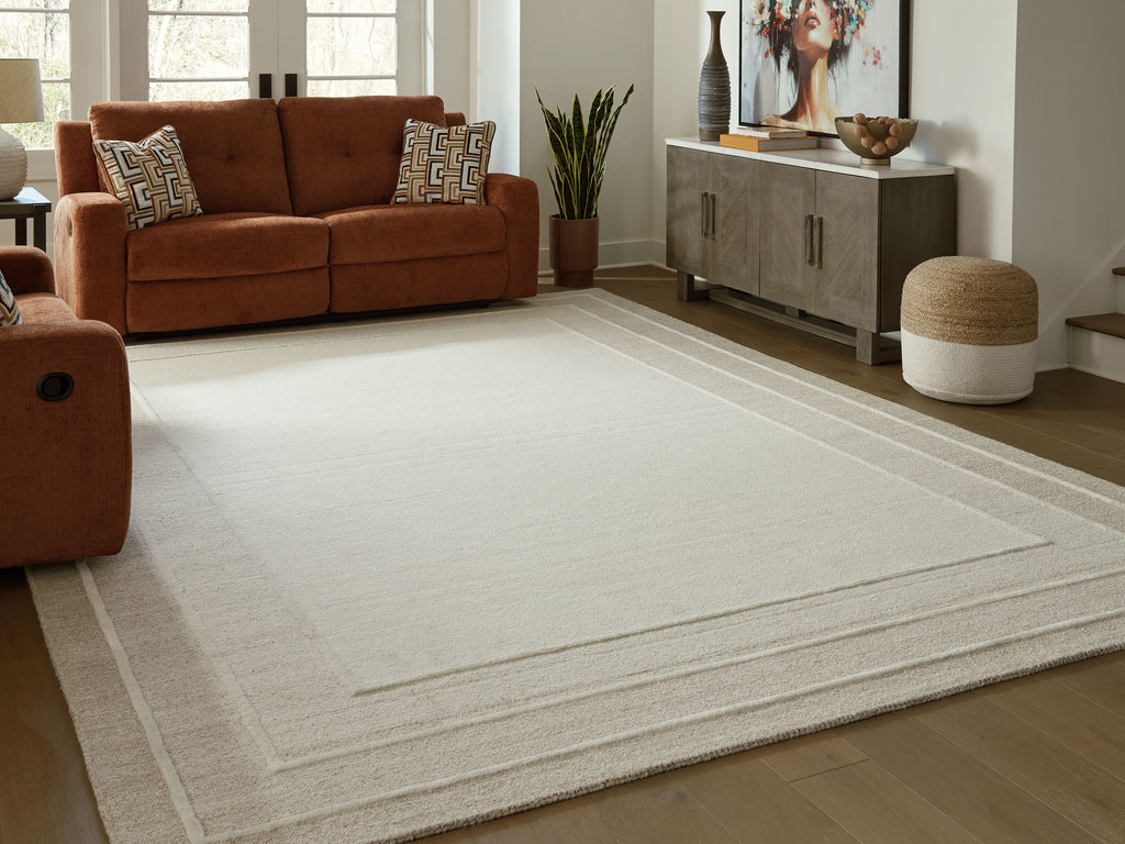 Beige area rug with wide border stripe and lightly textured flat woven look