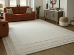 Beige area rug with wide border stripe and lightly textured flat woven look