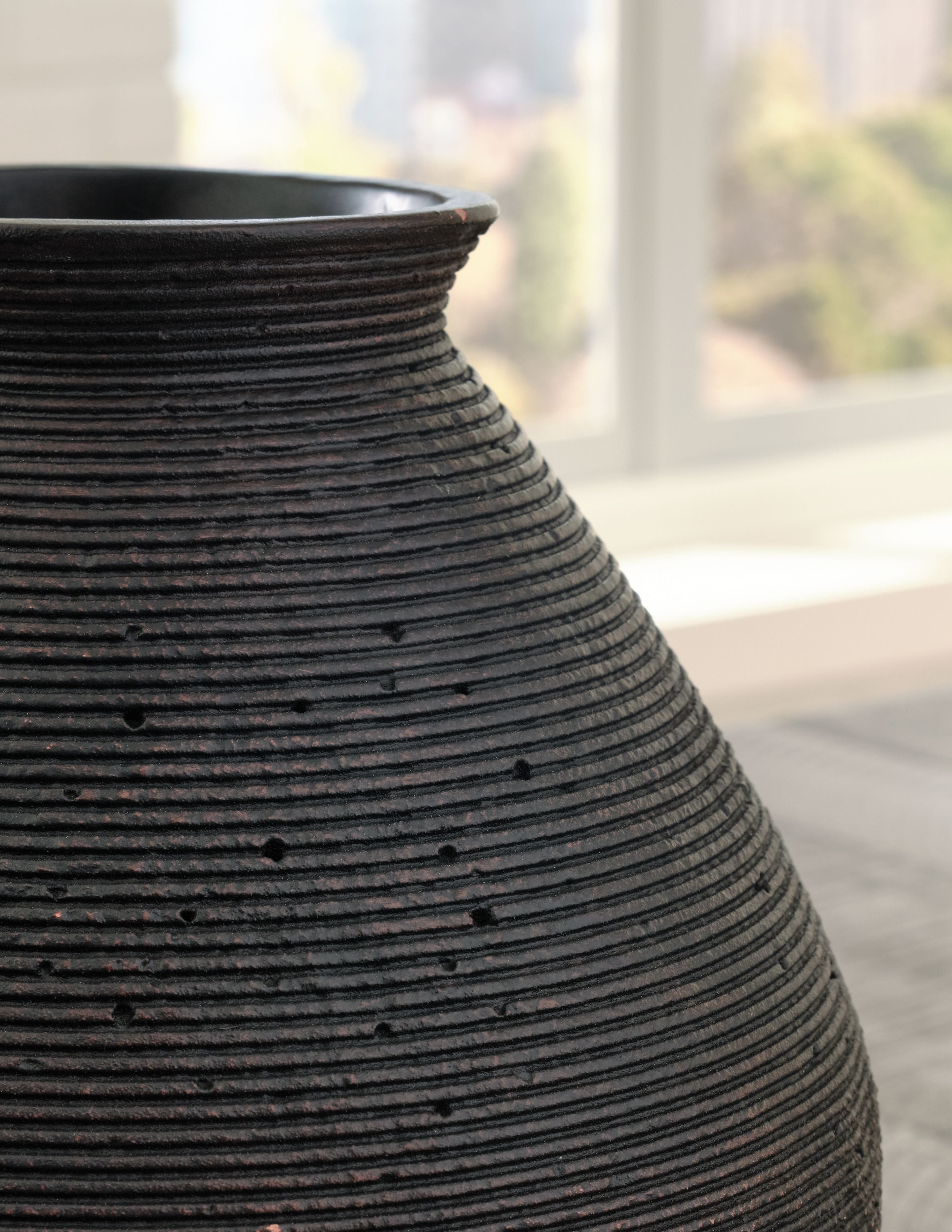 Dark brown ceramic vase with vertical ribbing and flared rim