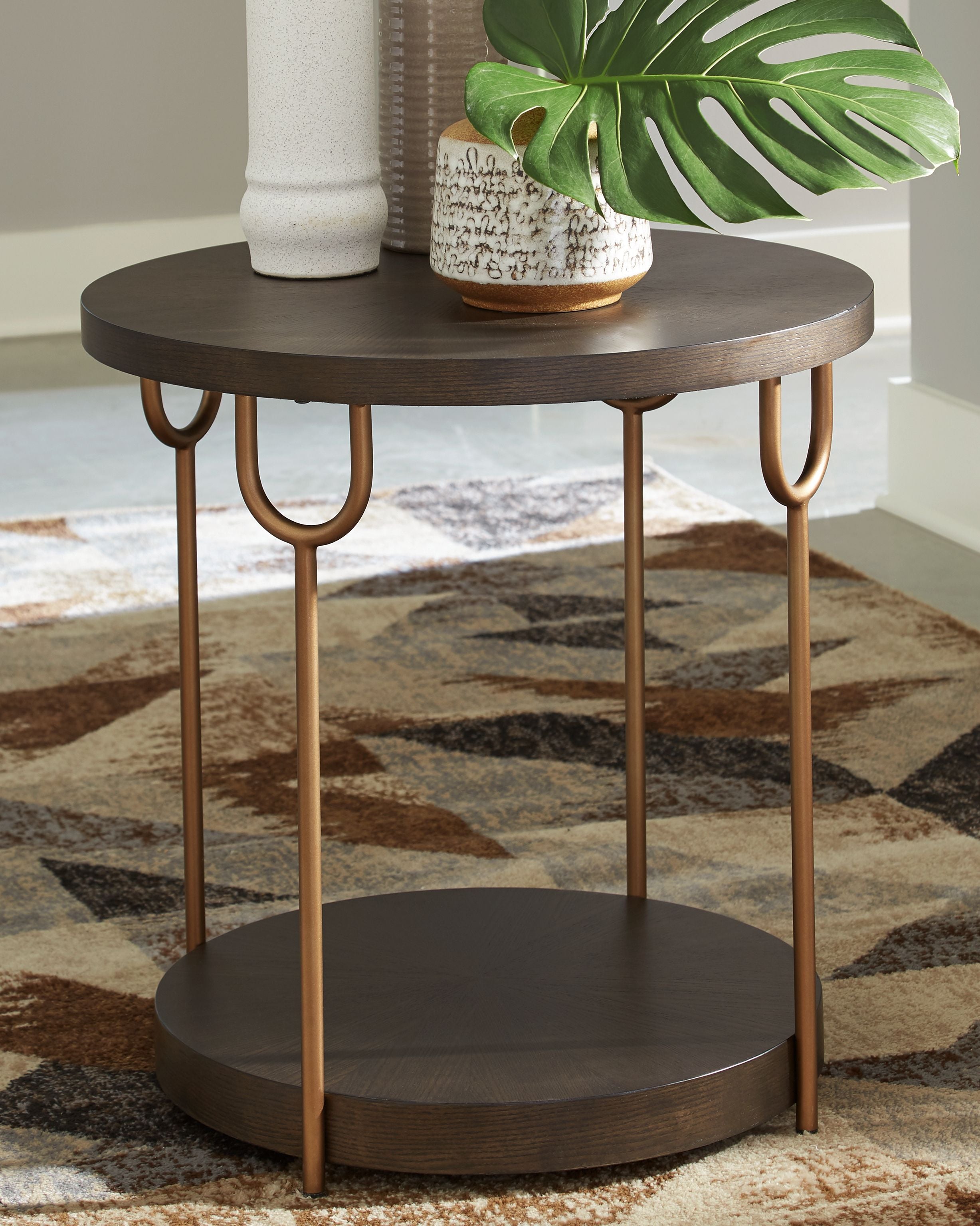 Round dark brown end table with two tiers and gold-finish U-shaped supports.