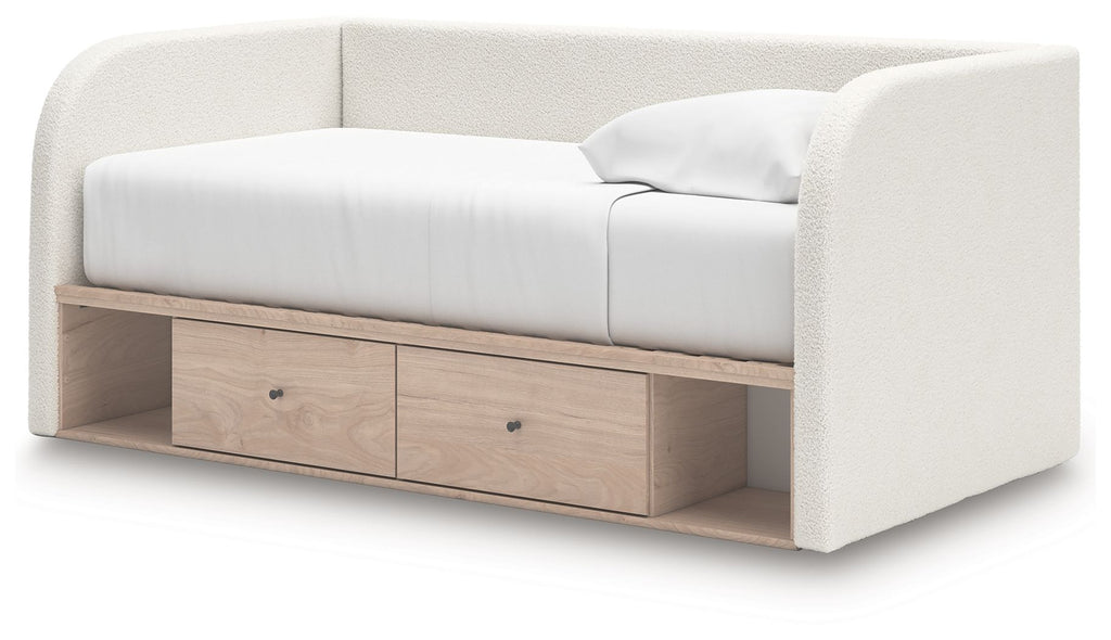 Upholstered day bed in beige fabric with white cushions; side view with two under-bed drawers