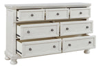 Antique white dresser with seven drawers and round knob pulls, partially opened drawer fronts.