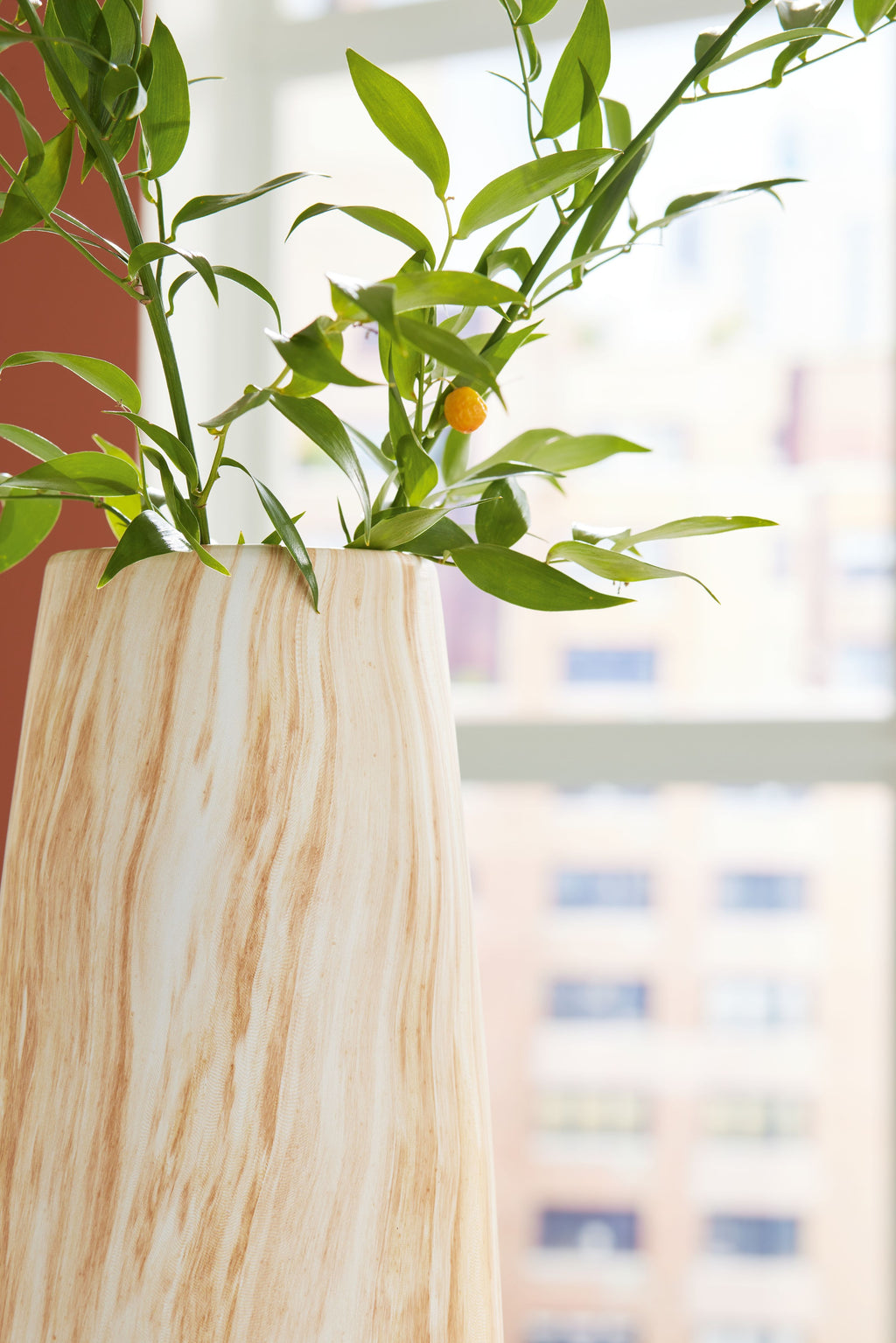 Beige marbled vase with leafy stems, rounded body and wide open mouth