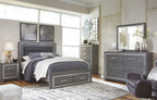 Gray panel bed with dark upholstered headboard and storage drawers, neatly styled bedding