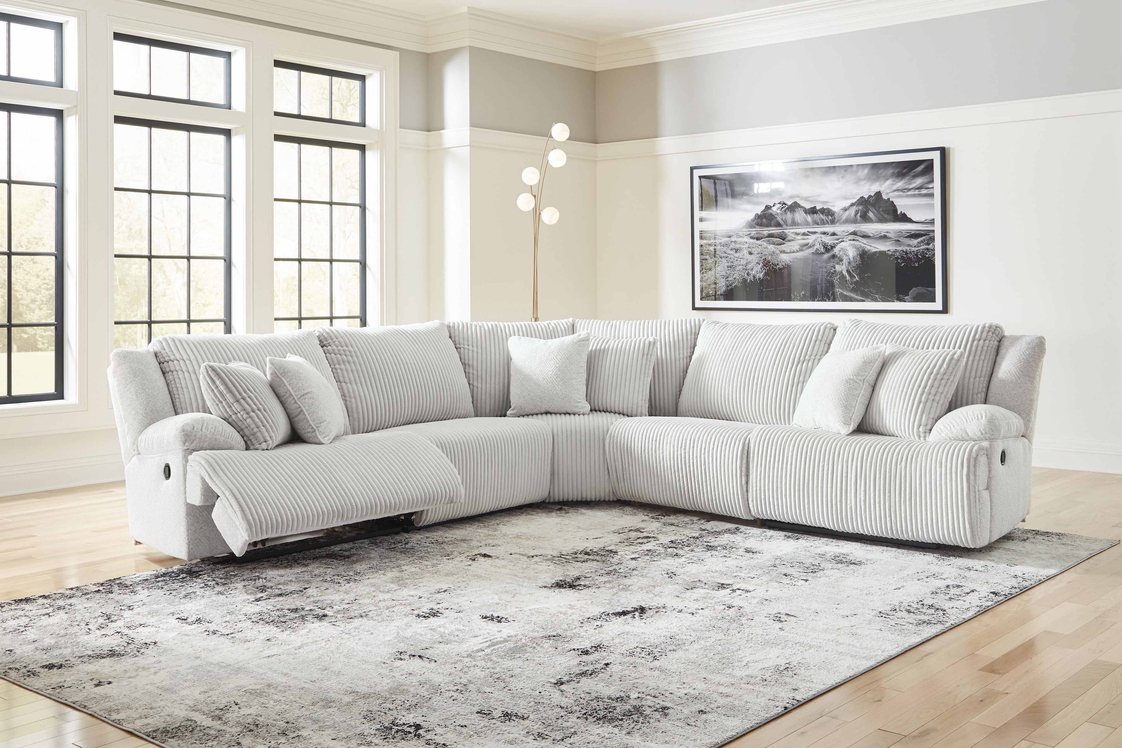 Light gray striped reclining sectional sofa with chaise and cushioned headrest pillows