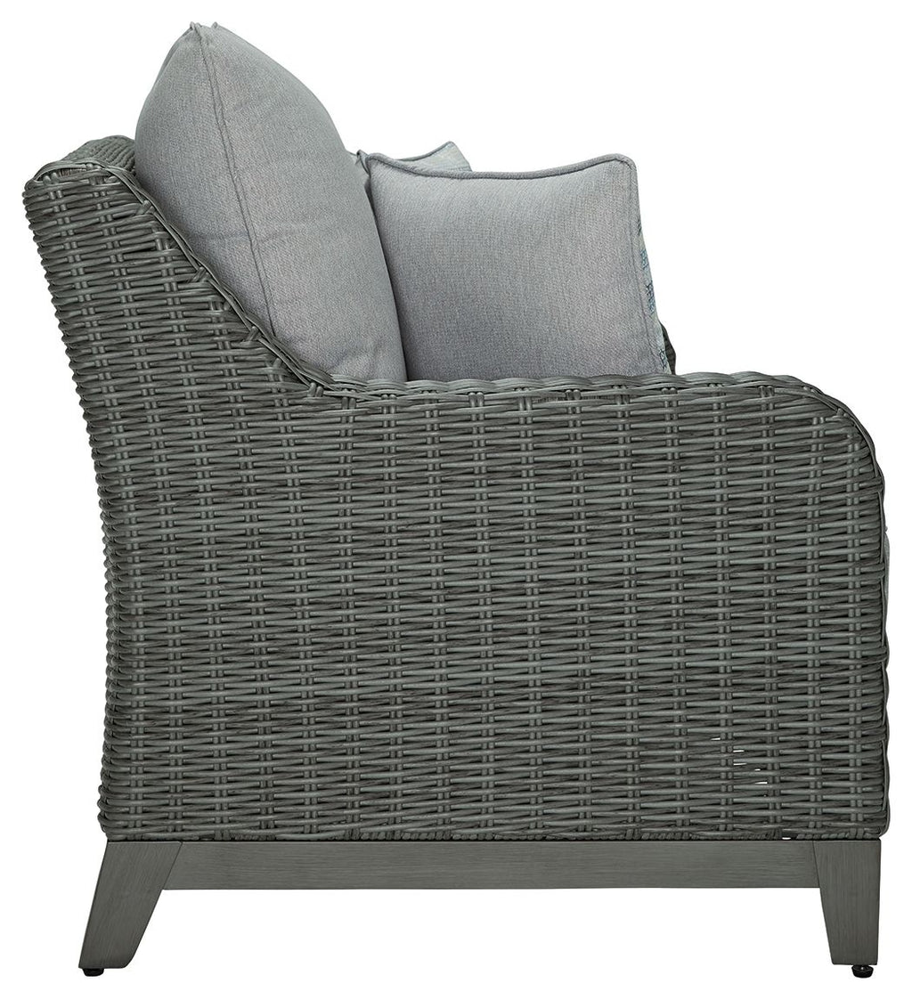 Gray wicker loveseat with tall back cushion and two pillows on the side