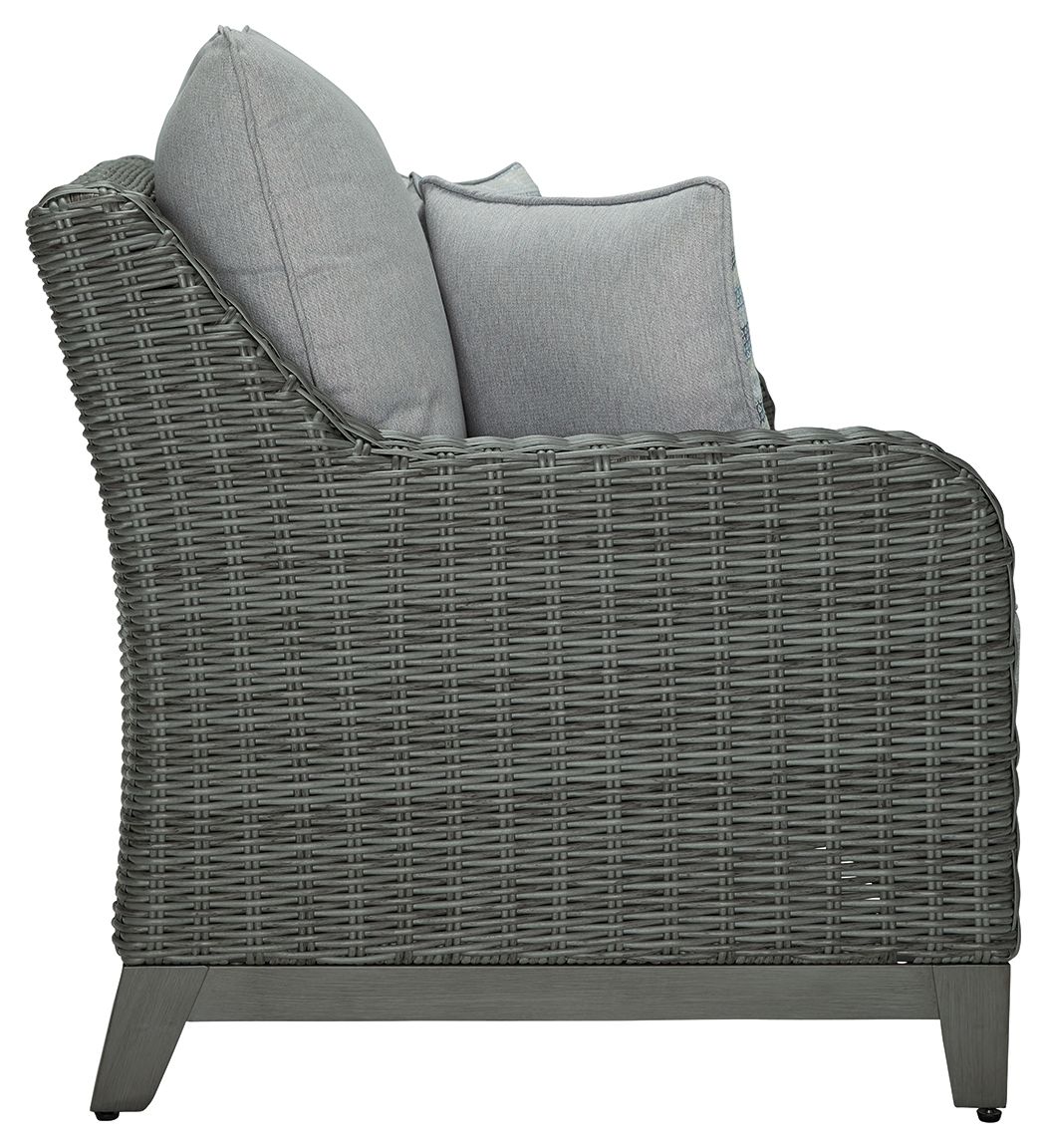 Gray wicker loveseat with tall back cushion and two pillows on the side