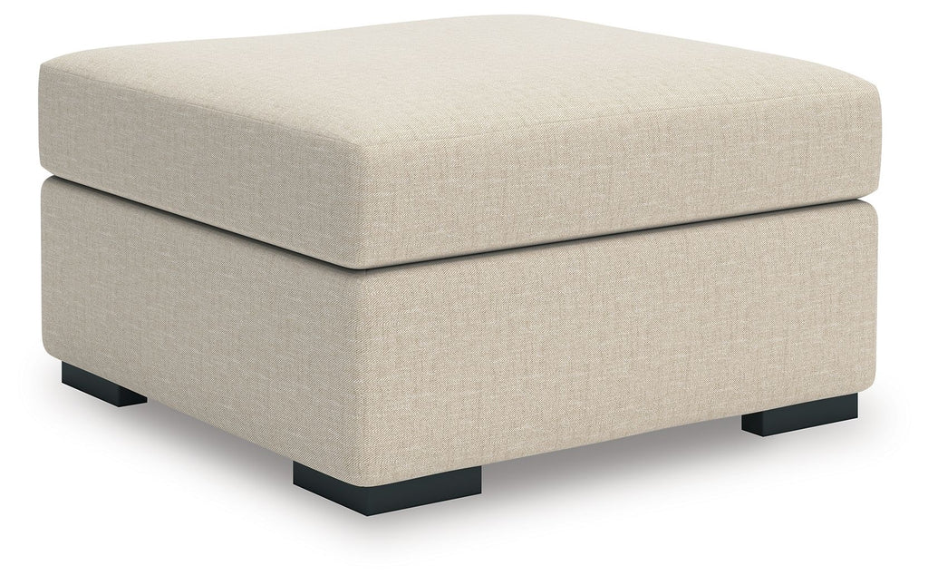 Light beige upholstered ottoman with square arms and black block feet