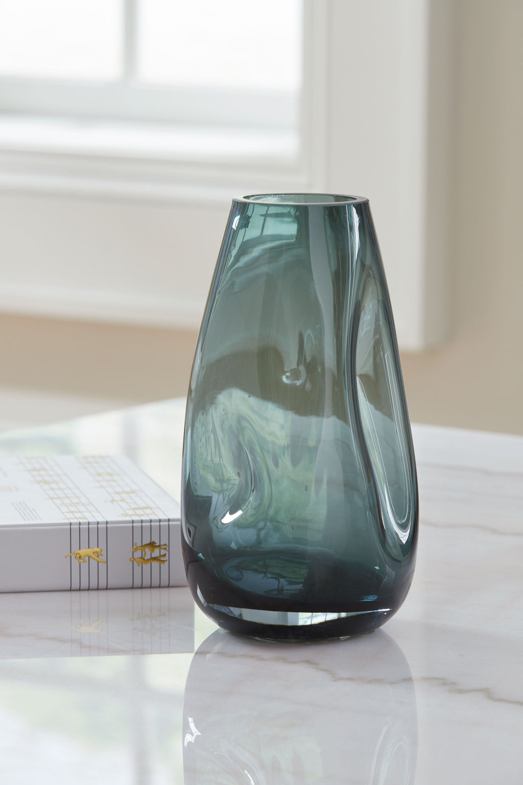 Light blue glass vase, rounded base and flared top opening