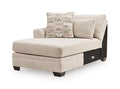 Light beige upholstered chaise lounge with patterned and solid throw pillows, dark legs