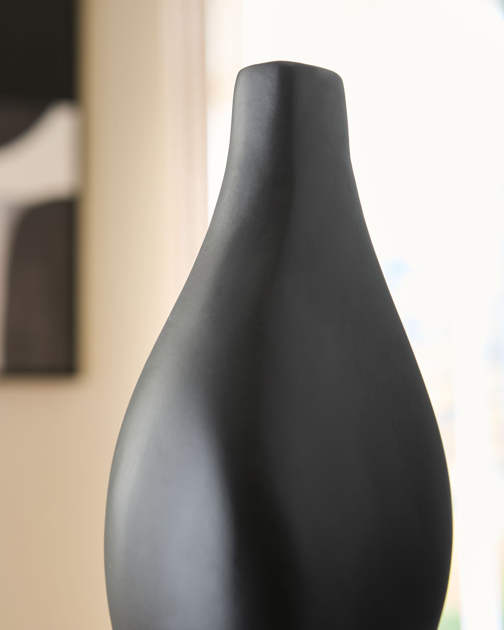 Black Judsen vase close-up showing rounded shoulders and narrow top opening.