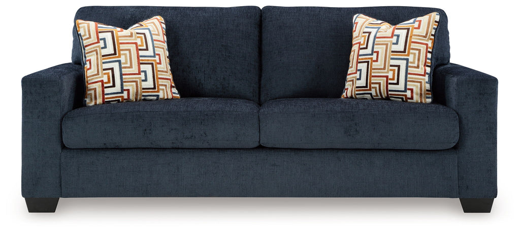 Dark navy upholstered sofa with two square patterned throw pillows.