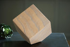 Tan wood sculpture block with blue-gray striped grain, faceted stepped side