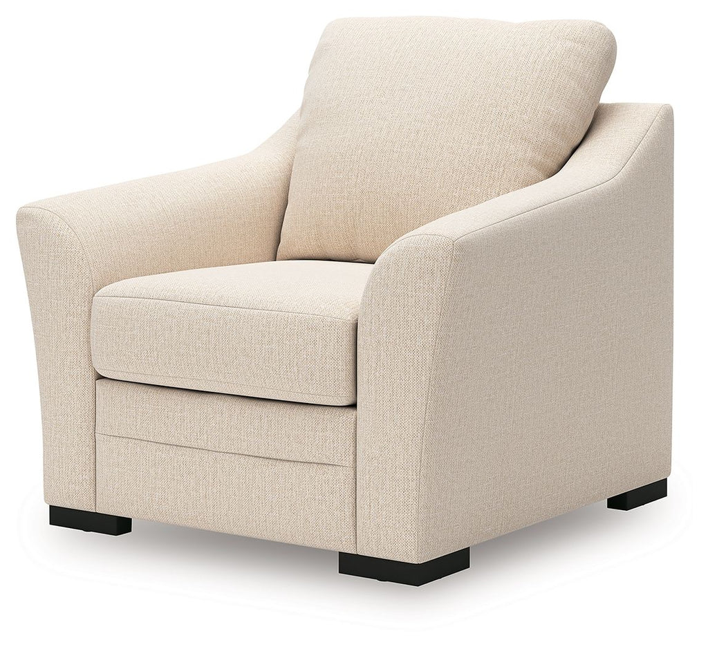 Beige upholstered lounge chair with rounded arms, cushioned seat, and black feet