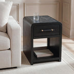 Black rectangular table with one drawer and open shelf, styled next to a sofa.
