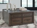 Square cocktail table with gray top and four brown drawers