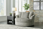 Gray oversized swivel accent chair with ribbed upholstery and three back pillows