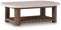Rectangular cocktail table with beige round top and woven brown wicker base