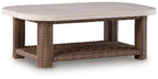 Rectangular cocktail table with beige round top and woven brown wicker base