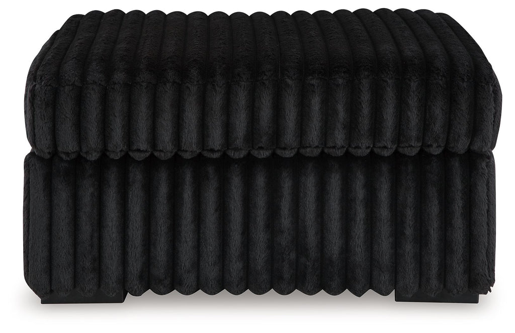 Oversized accent ottoman in dark color, vertical ribbed texture, low profile