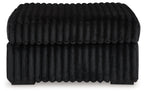 Oversized accent ottoman in dark color, vertical ribbed texture, low profile