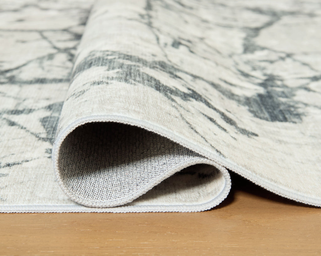 Washable rug close-up: beige-and-gray marble pattern with rolled edge binding