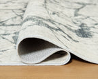 Washable rug close-up: beige-and-gray marble pattern with rolled edge binding