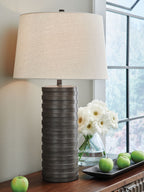 Table lamp with off-white fabric shade and dark ribbed poly base
