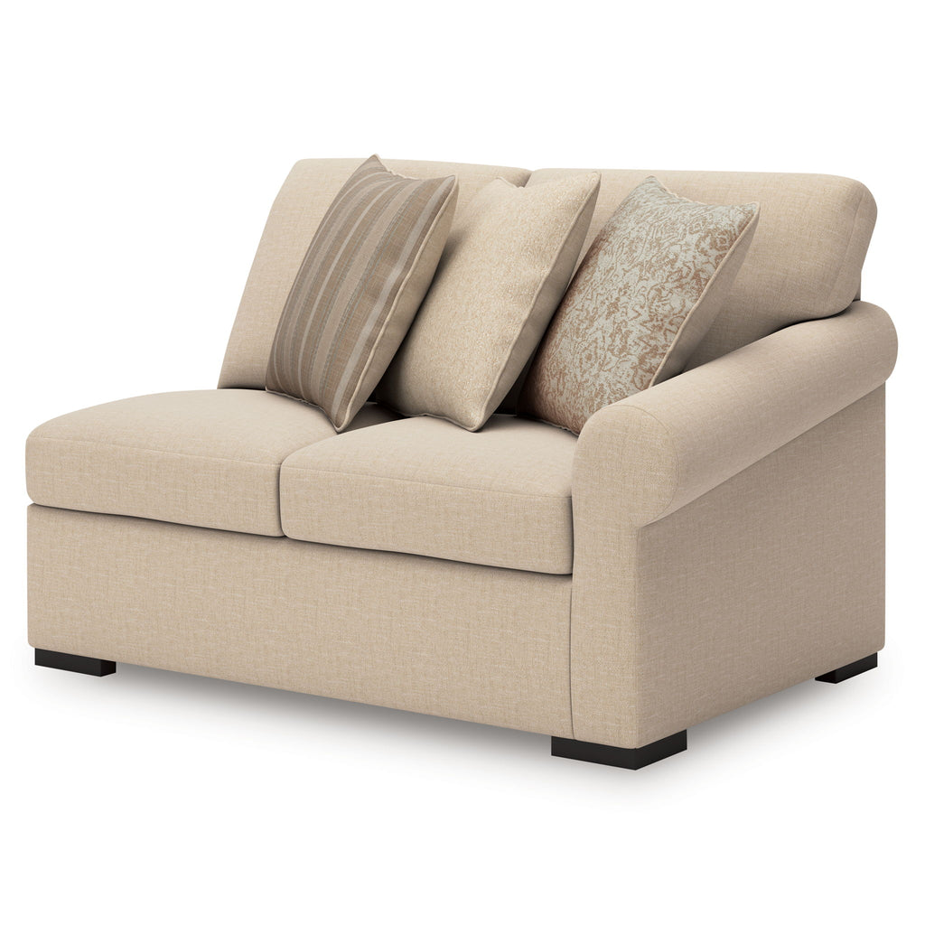 Cream upholstered chaise with three pillows in striped and floral patterns