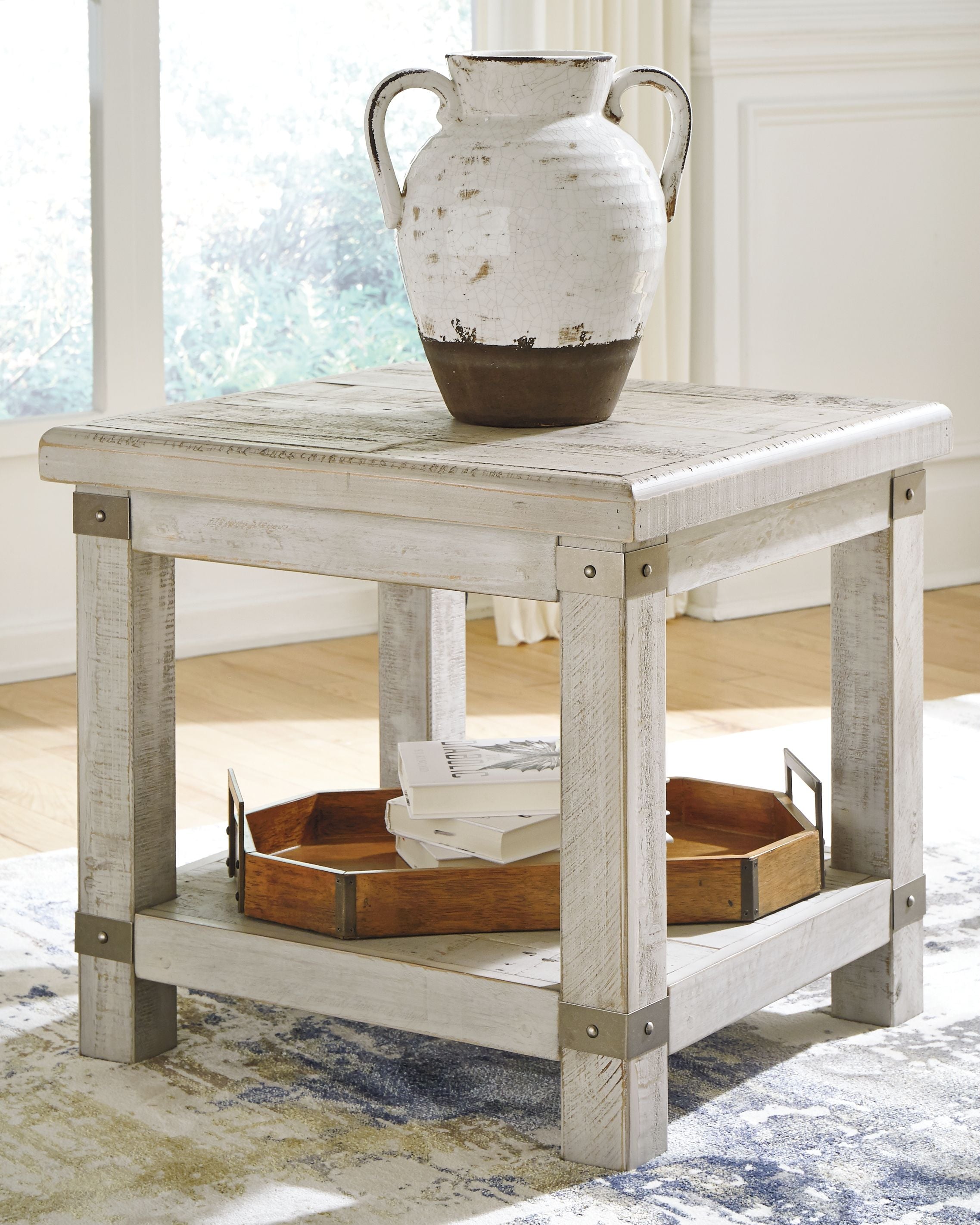 Rectangular end table with whitewashed gray top and open lower shelf, styled with vase