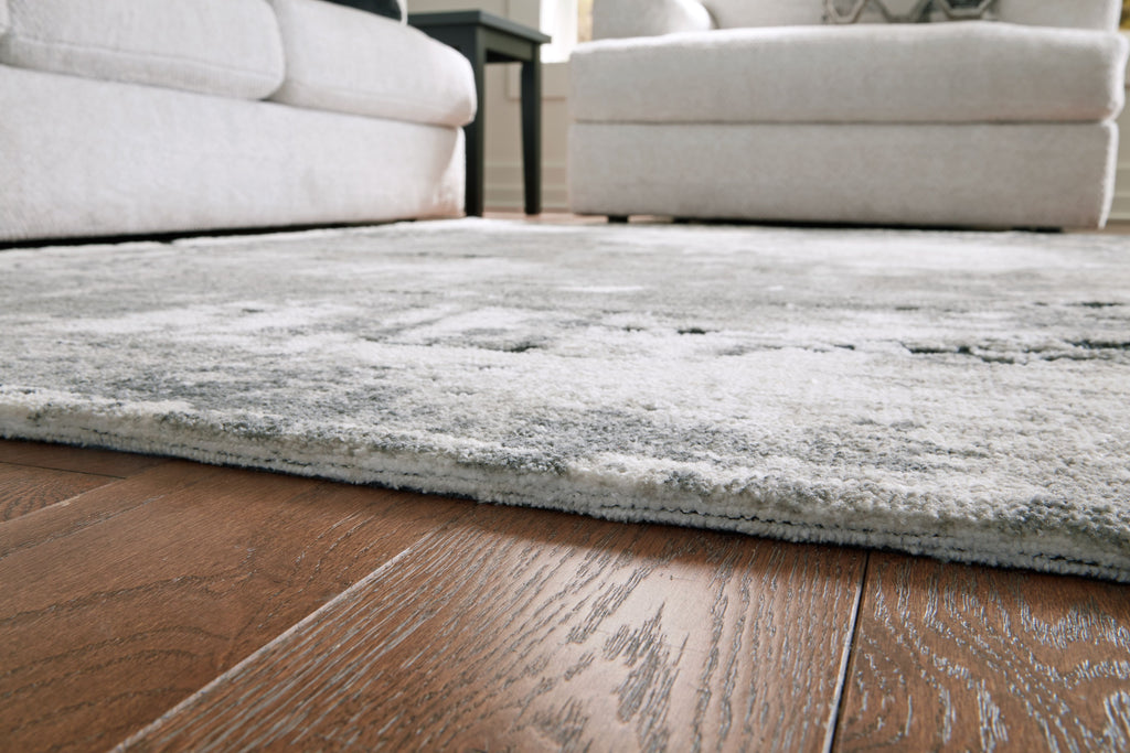 Gray area rug corner edge, low pile with distressed speckled pattern