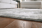 Gray area rug corner edge, low pile with distressed speckled pattern