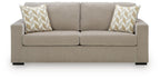 Light gray sofa sleeper with two patterned throw pillows and centered back seam