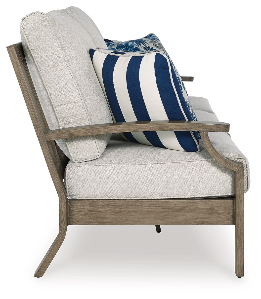 Light gray accent sofa chair with blue striped and floral throw cushion, dark wood arms