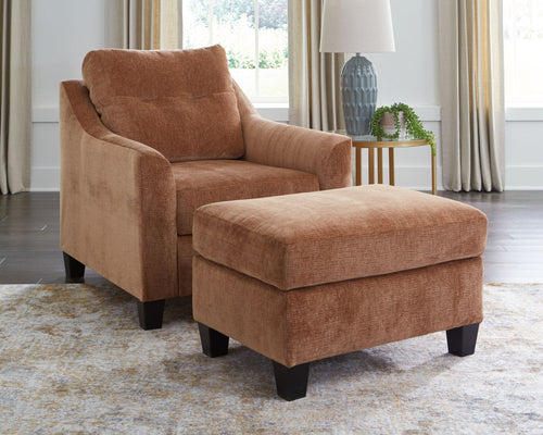 Brown upholstered accent chair set with ottoman, curved arms, and black feet