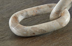 Light beige abstract sculpture link loop detail with curled ends