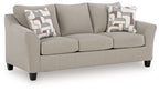 Taupe upholstered loveseat with two central back cushions, geometric patterned pillows