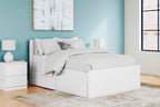 White panel platform bed with low front storage drawers and neatly styled bedding