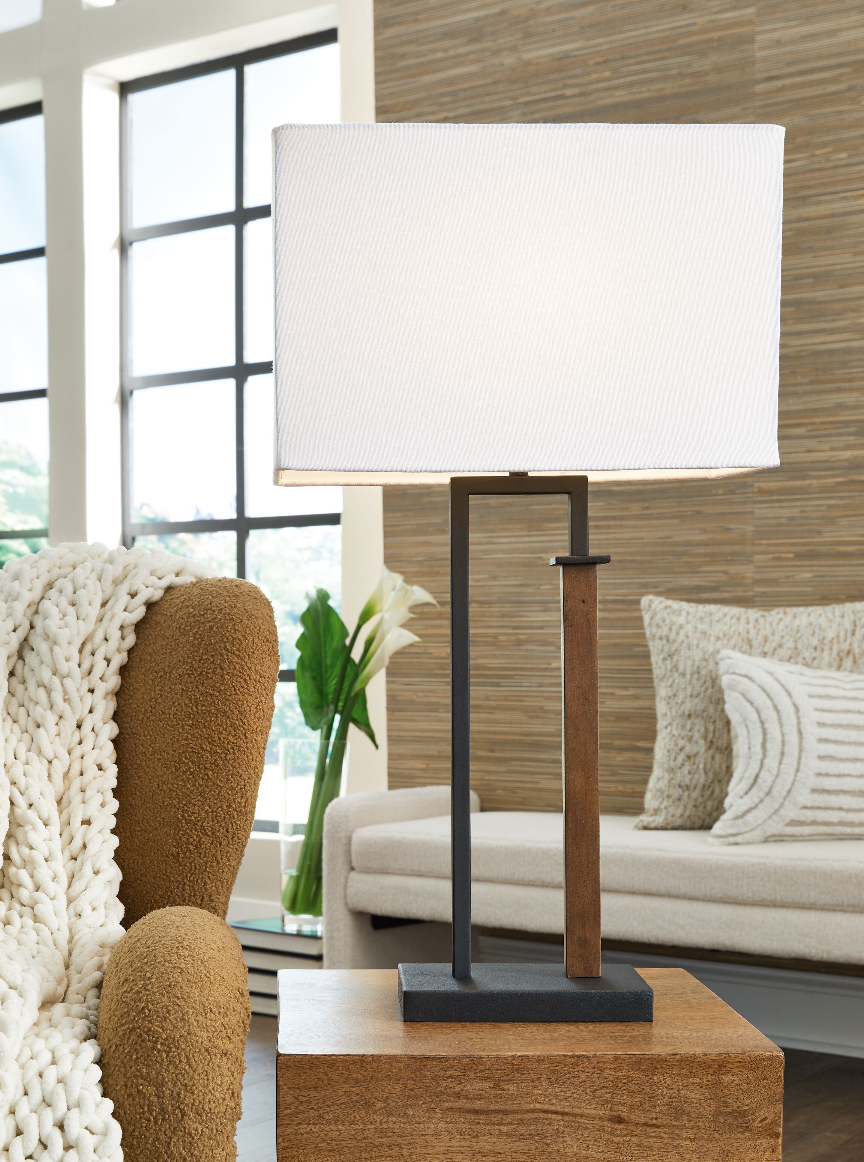 Metal table lamp set with black frame, brown wood column, and white shade on table