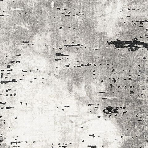 Gray rug close-up with distressed black speckles and mottled texture