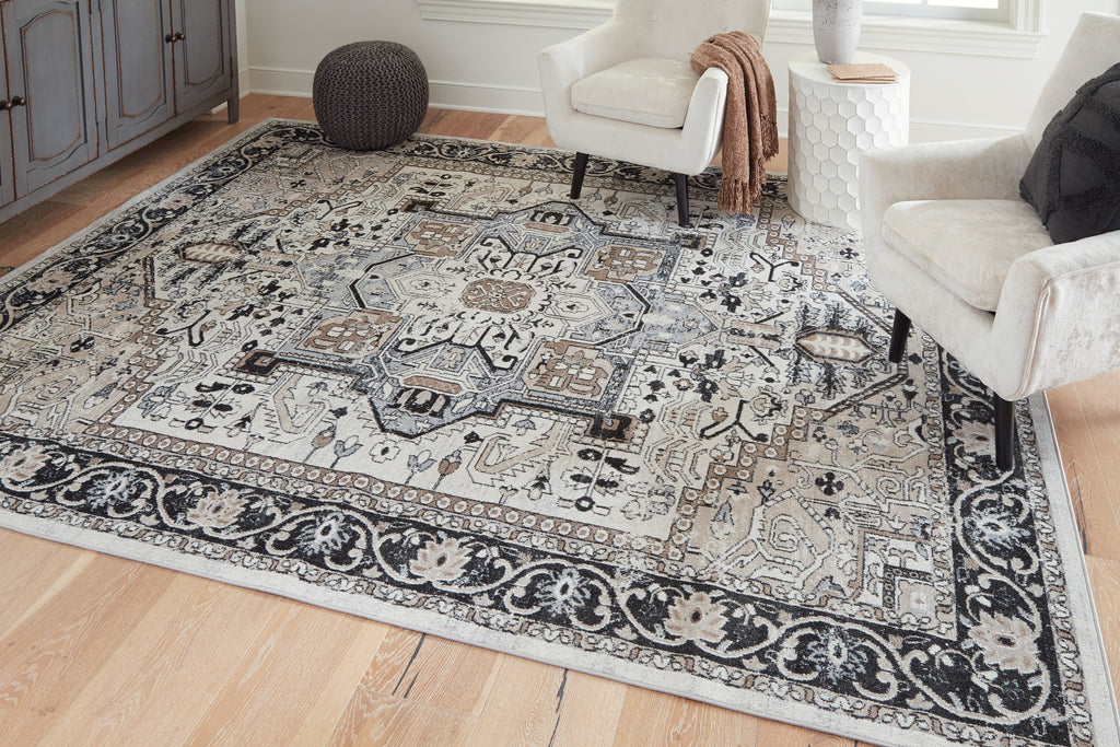 Light gray area rug with black filigree pattern panels and central medallion