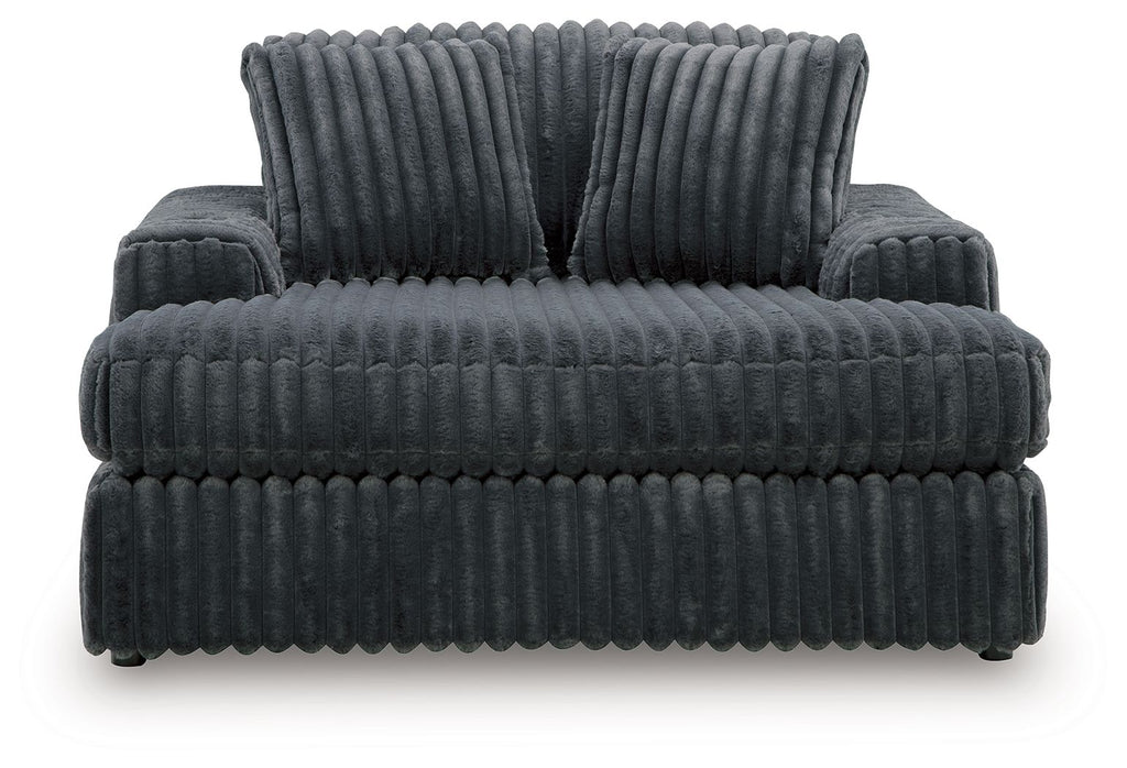 Oversized dark gray chaise front view with thick channel tufted cushions