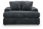 Oversized dark gray chaise front view with thick channel tufted cushions