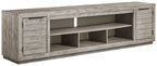 Gray TV stand with two cabinet doors and open shelving for media devices