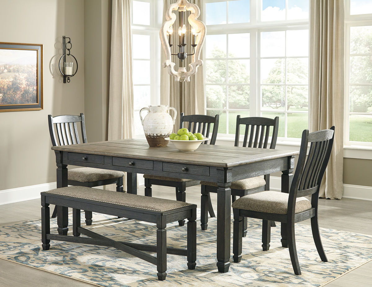 Dark gray dining table with two upholstered benches and four slat-back chairs