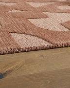 Perrenton rug border close-up, short textured pile with abstract tan motif