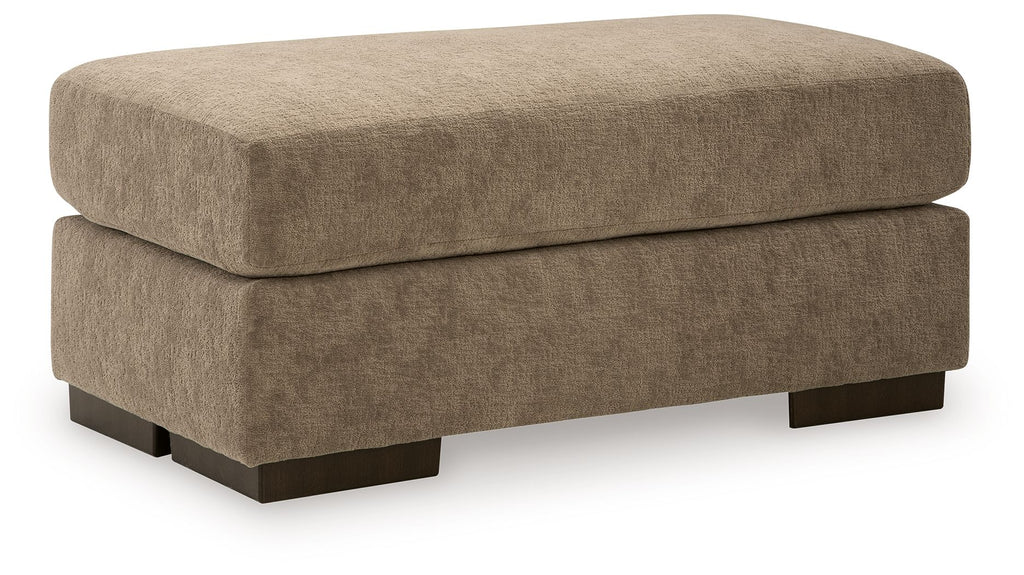 Fabric ottoman in light brown with padded top and dark wooden legs.