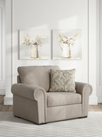 Chair and a half in heather light-gray upholstery with patterned throw pillow