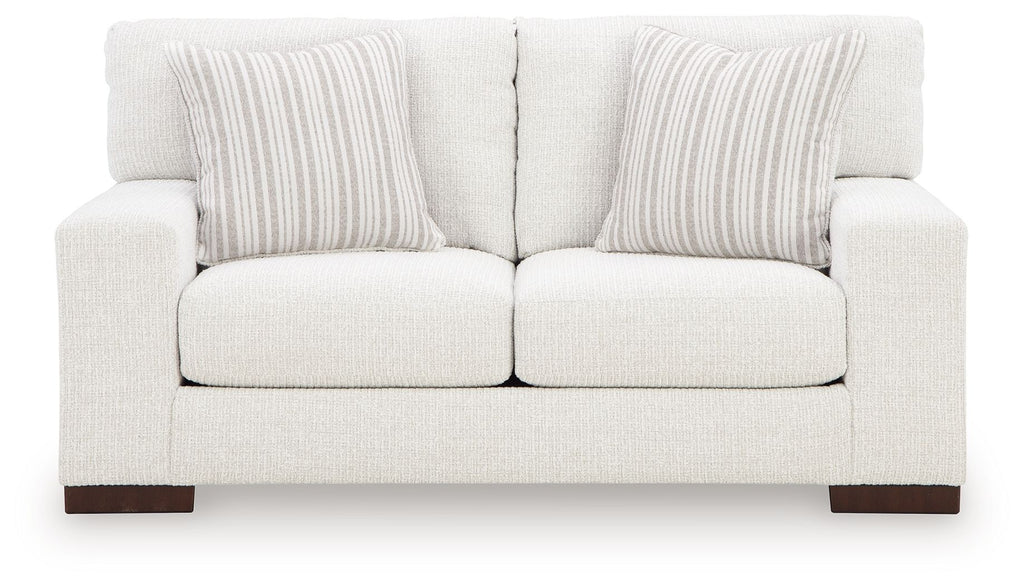 Frosted white loveseat with three back cushions, central seam, and striped pillows
