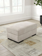 Taupe upholstered ottoman with black block legs and square top cushion
